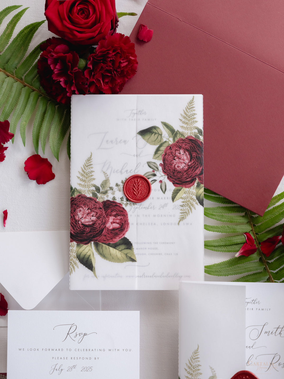 Invitación con manga de pergamino de caligrafía moderna con detalles florales de color rojo intenso y sello de cera de Burdeos