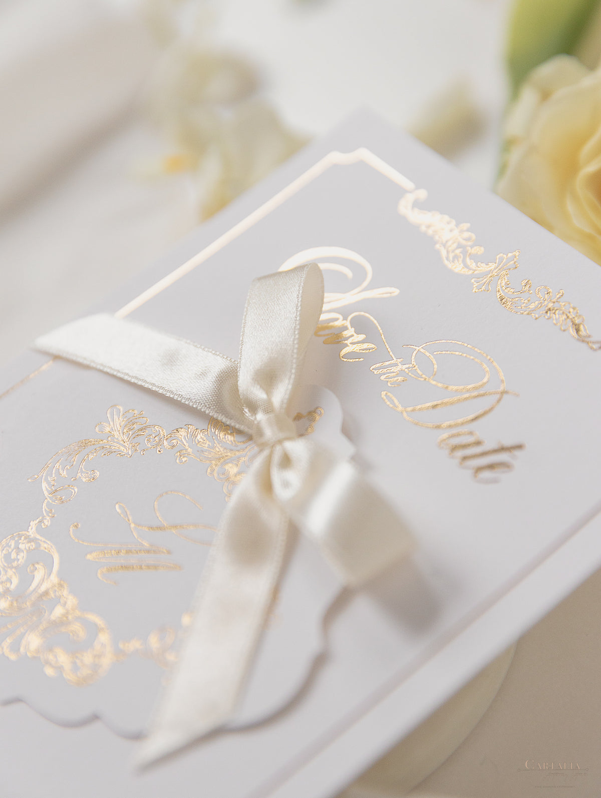 Tarjeta y etiqueta de lámina dorada de lujo con monograma y cinta de raso para guardar la fecha
