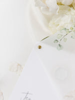 Recepción nocturna de hortensias blancas y capa de pergamino y etiqueta hexagonal con perno plateado y espejo plateado