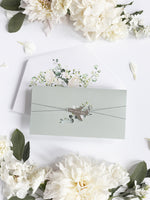 Carpeta de hortensias de boda en verde salvia, invitación para pasaporte y etiqueta de avión con espejo