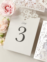 Tarjetas románticas con números de mesa con flores cortadas con láser y monogramas