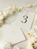 Tarjetas románticas con números de mesa con flores cortadas con láser y monogramas